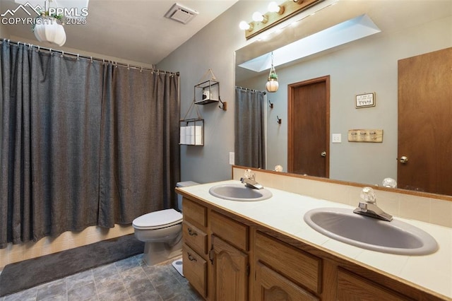 bathroom featuring visible vents, a sink, toilet, and double vanity
