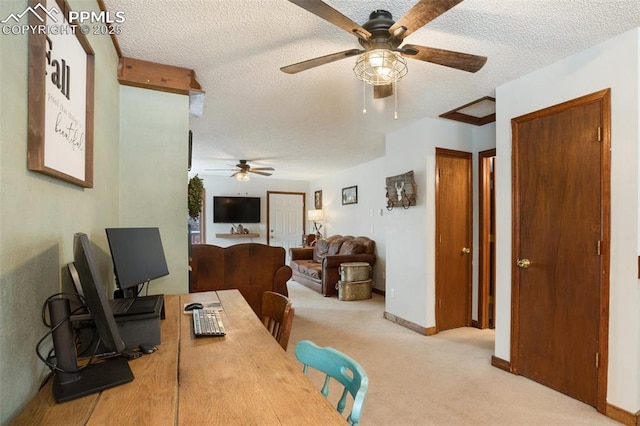 carpeted office featuring a textured ceiling, ceiling fan, and baseboards