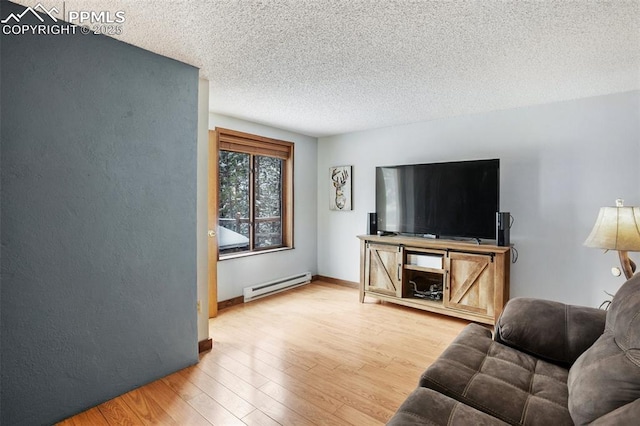 living area with baseboards, a textured ceiling, wood finished floors, and a baseboard heating unit