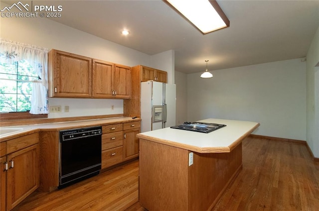 3012 S Electra Dr, Colorado Springs, CO 80906 - kitchen featuring black appliances, light wood-style flooring, a kitchen island, brown cabinetry, and light countertops