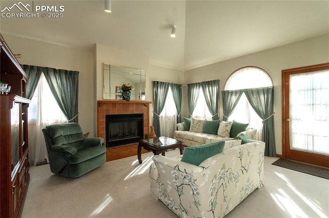 3012 S Electra Dr, Colorado Springs, CO 80906 - living room with carpet, a tile fireplace, plenty of natural light, and lofted ceiling