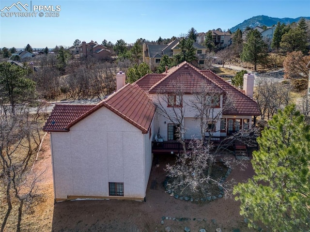 3012 S Electra Dr, Colorado Springs, CO 80906 - back of property with a chimney, a tile roof, and stucco siding