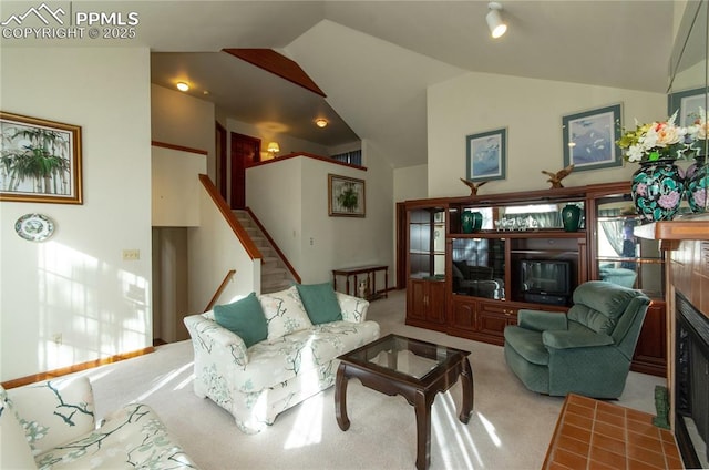 3012 S Electra Dr, Colorado Springs, CO 80906 - carpeted living room with lofted ceiling, stairway, and a tile fireplace