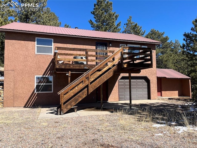 exterior space featuring stucco siding, metal roof, a wooden deck, and stairway