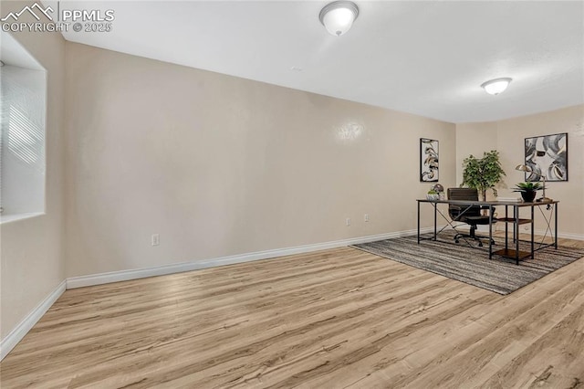 office area with baseboards and light wood finished floors