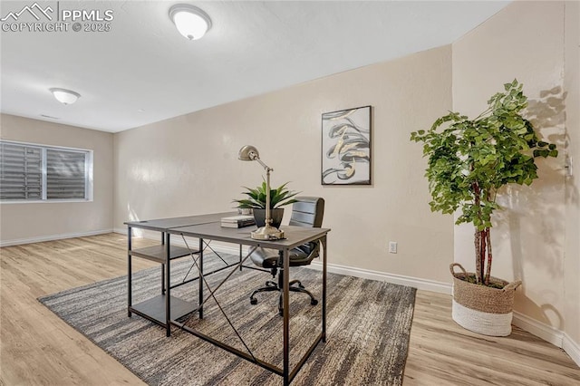 office area featuring baseboards and light wood-style flooring