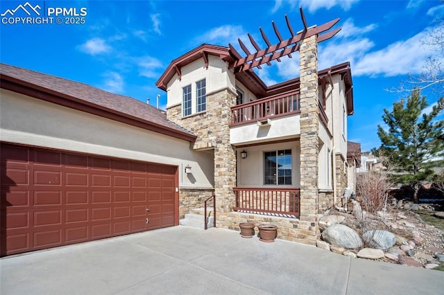 view of front of house with stucco siding, stone siding, a balcony, and a porch