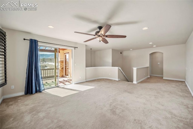 unfurnished room featuring arched walkways, recessed lighting, baseboards, and carpet