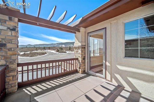 balcony featuring a mountain view and a pergola