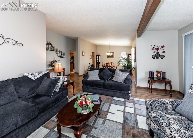 living room featuring a chandelier, beam ceiling, a textured ceiling, and wood finished floors