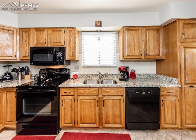 kitchen featuring a sink, light stone counters, tasteful backsplash, and black appliances