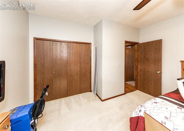 bedroom featuring a ceiling fan, a textured ceiling, a closet, carpet flooring, and baseboards