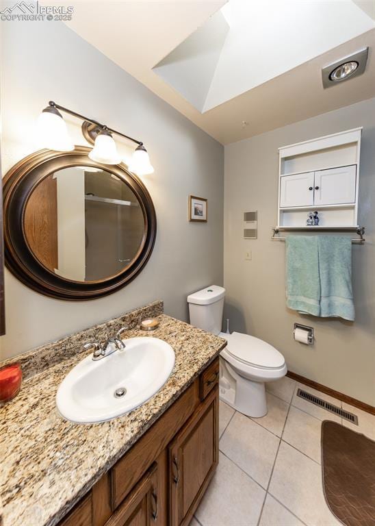 bathroom with vanity, visible vents, baseboards, tile patterned flooring, and toilet