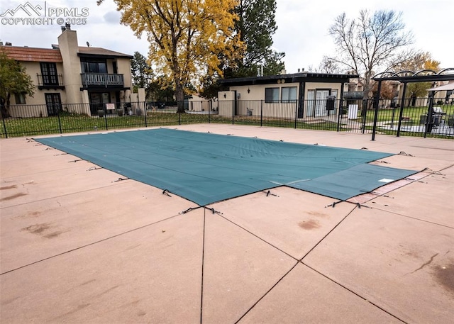 community pool featuring a patio area and fence