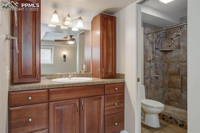 full bathroom with a ceiling fan, tiled shower, toilet, and vanity