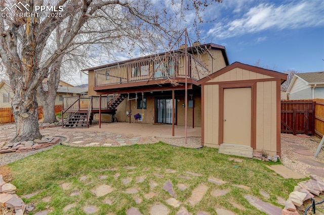 rear view of house featuring an outbuilding, a fenced backyard, a shed, stairway, and a patio area