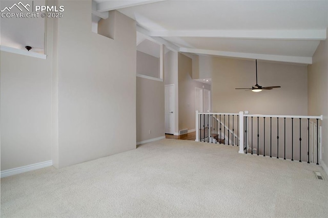 unfurnished room with visible vents, beam ceiling, carpet, and ceiling fan