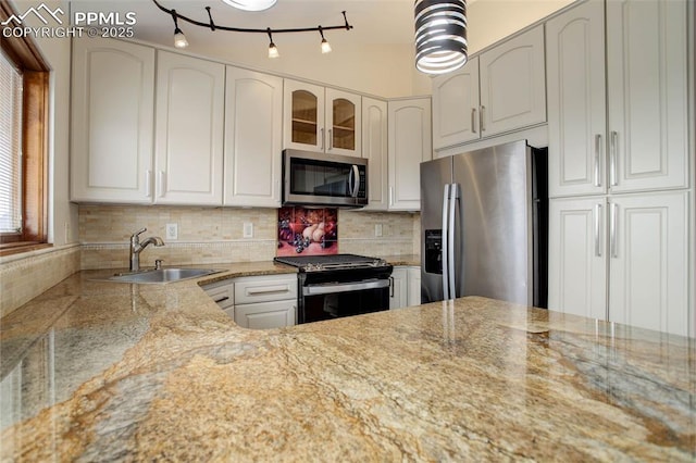 kitchen with a sink, glass insert cabinets, tasteful backsplash, and stainless steel appliances