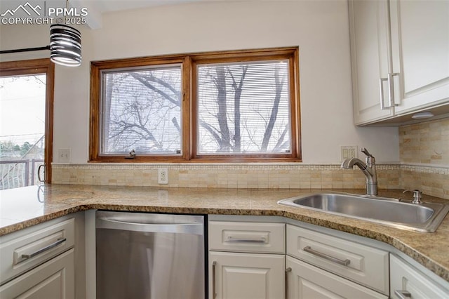 kitchen with pendant lighting, dishwasher, decorative backsplash, white cabinetry, and a sink