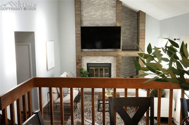 interior space with a fireplace, lofted ceiling, and wood finished floors