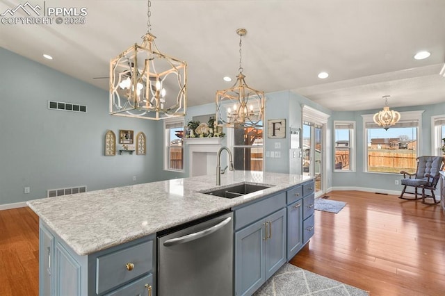 kitchen featuring visible vents, dishwasher, an island with sink, and a sink