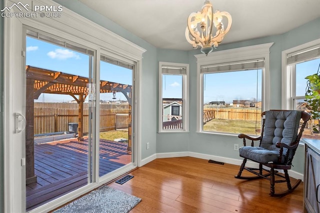 sunroom / solarium featuring a chandelier and visible vents