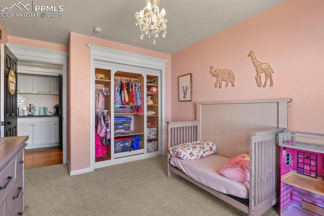 bedroom featuring light colored carpet and a chandelier