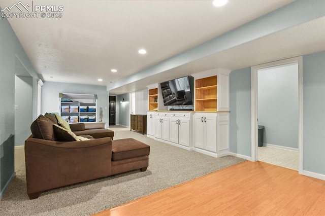 living area with recessed lighting, baseboards, and light wood-style flooring