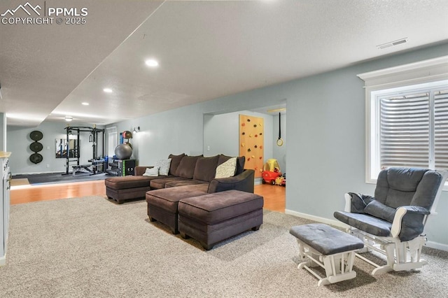 living area with visible vents, recessed lighting, a textured ceiling, and baseboards