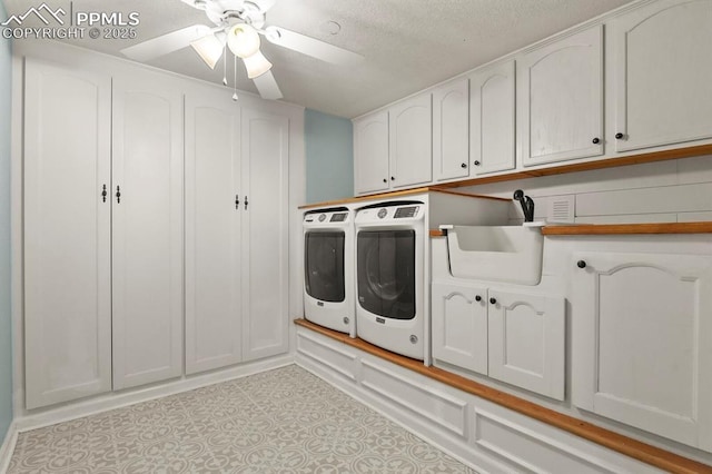 laundry room featuring cabinet space, washer and dryer, a textured ceiling, and ceiling fan