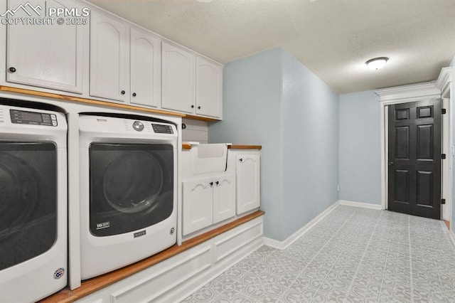 clothes washing area featuring washer and dryer, cabinet space, baseboards, and a textured ceiling