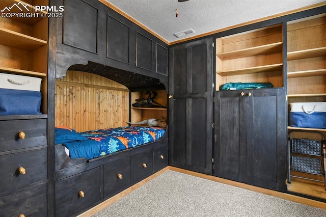 carpeted bedroom featuring visible vents and a textured ceiling