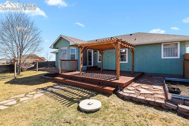 back of house featuring stucco siding, a pergola, fence, a yard, and a wooden deck