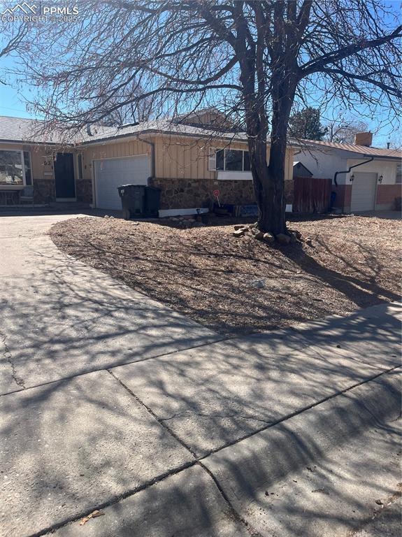 view of side of home featuring an attached garage and driveway