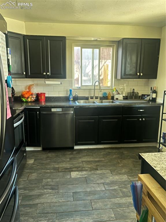 kitchen featuring dark wood finished floors, decorative backsplash, dishwasher, and a sink