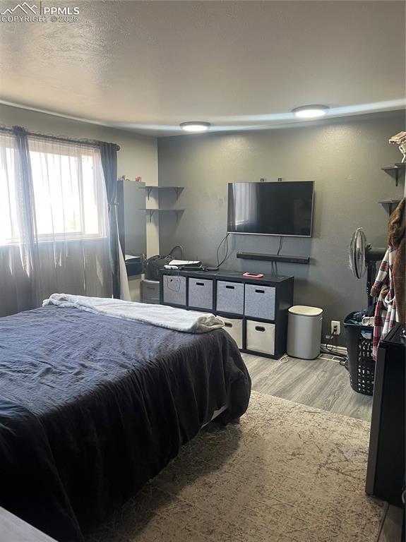 bedroom with a textured ceiling and wood finished floors