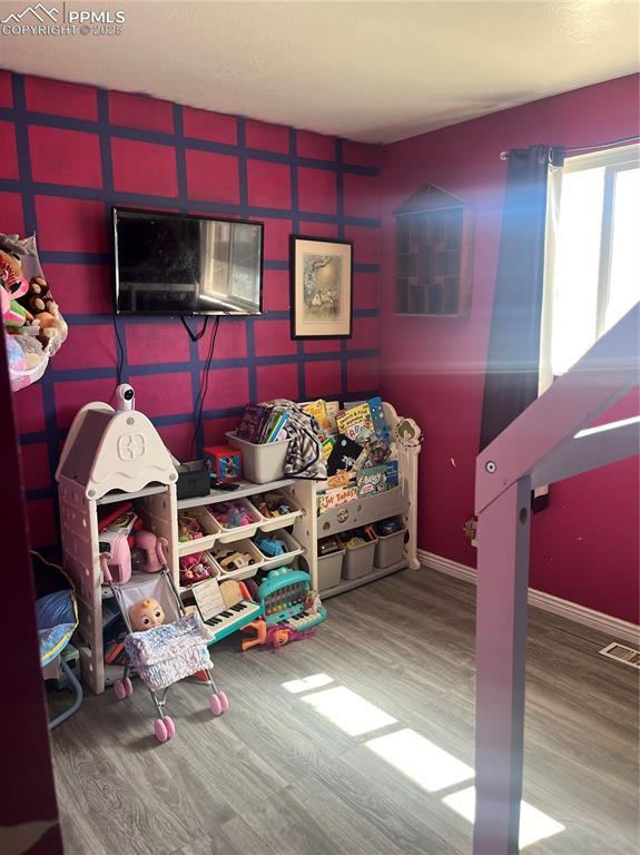 rec room featuring visible vents, wood finished floors, and baseboards