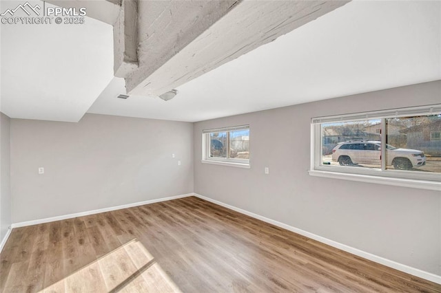 empty room with visible vents, baseboards, and wood finished floors