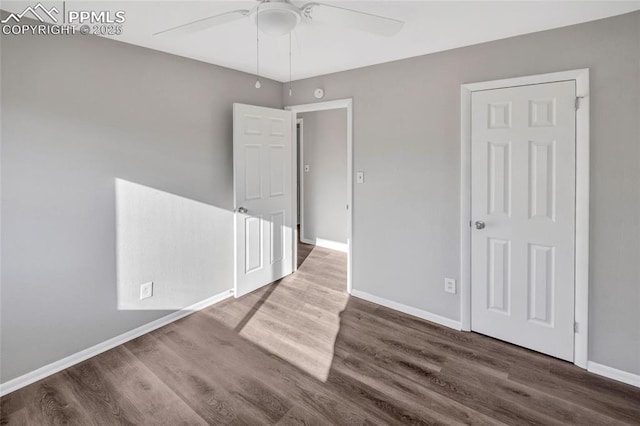 empty room with ceiling fan, baseboards, and wood finished floors