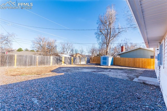 view of yard with a fenced backyard, a storage shed, and an outdoor structure