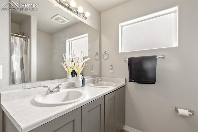 full bathroom featuring double vanity, visible vents, a shower with shower curtain, and a sink