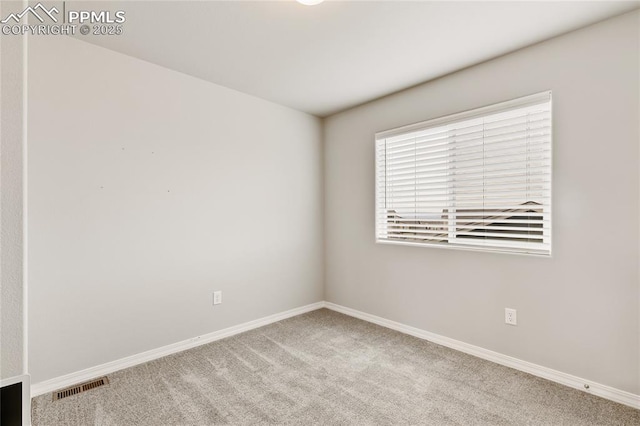 carpeted spare room featuring visible vents and baseboards