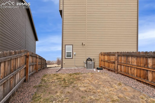 view of yard featuring central AC unit and fence