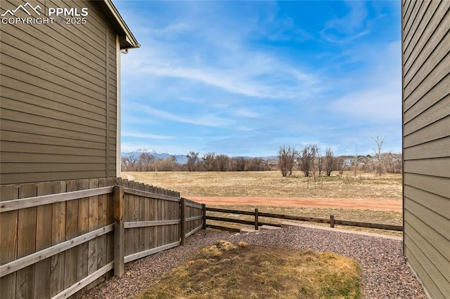 view of yard featuring a rural view and fence