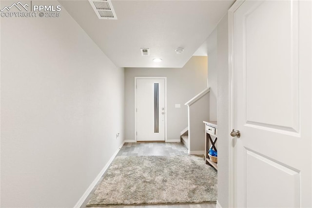 foyer featuring visible vents, stairway, and baseboards