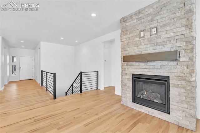 unfurnished living room with a fireplace, recessed lighting, and wood finished floors