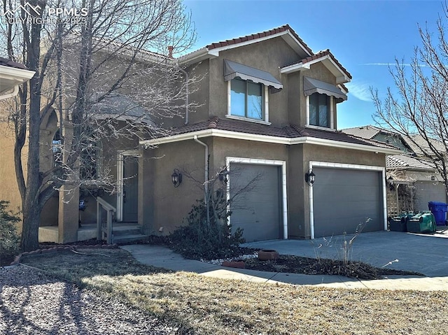 view of front of property featuring stucco siding, a tiled roof, driveway, and a garage