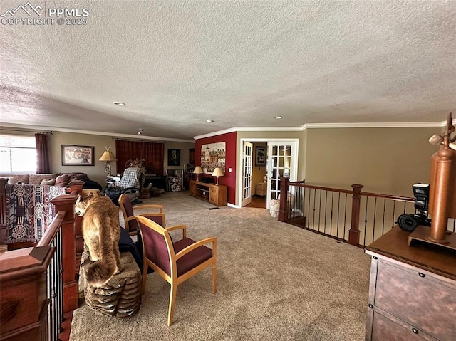 living area with carpet floors, a textured ceiling, and ornamental molding