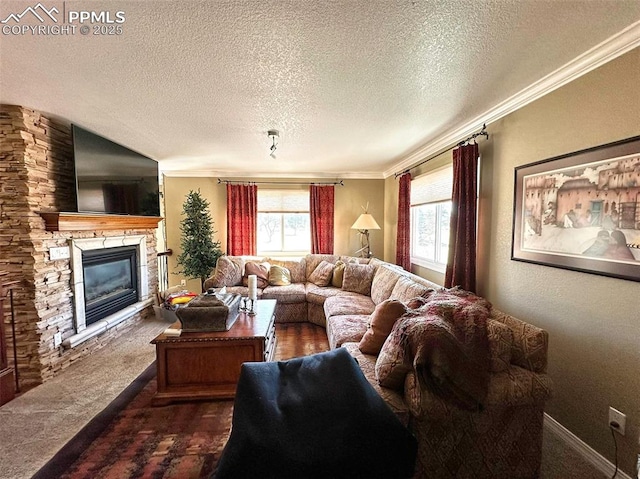 living area with baseboards, dark carpet, ornamental molding, a stone fireplace, and a textured ceiling