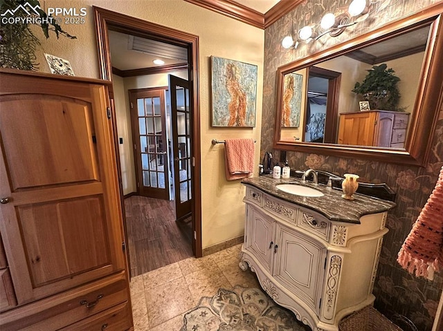 bathroom featuring french doors, vanity, baseboards, and ornamental molding